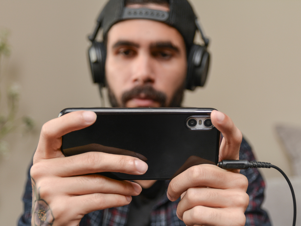 man playing an iGaming website on his mobile phone